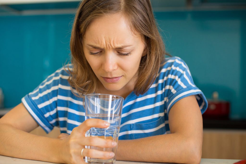 woman examining her drinking water