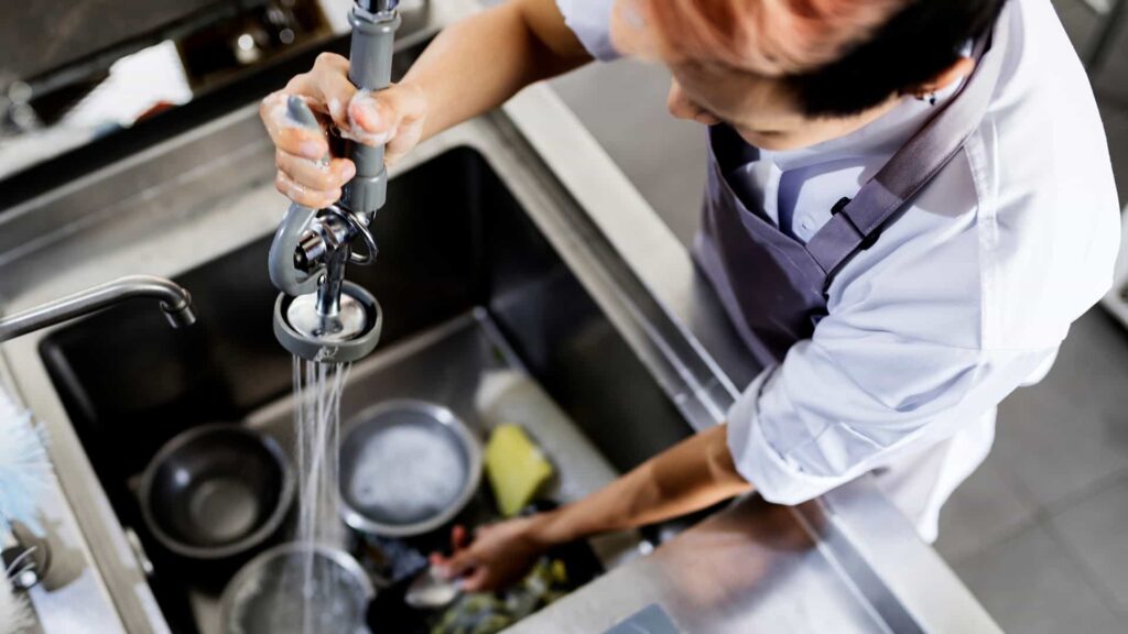 Restaurant worker washing dishes
