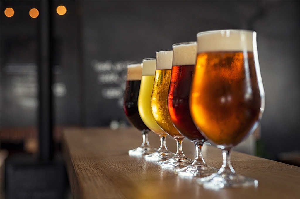 types of beers lined up at a bar