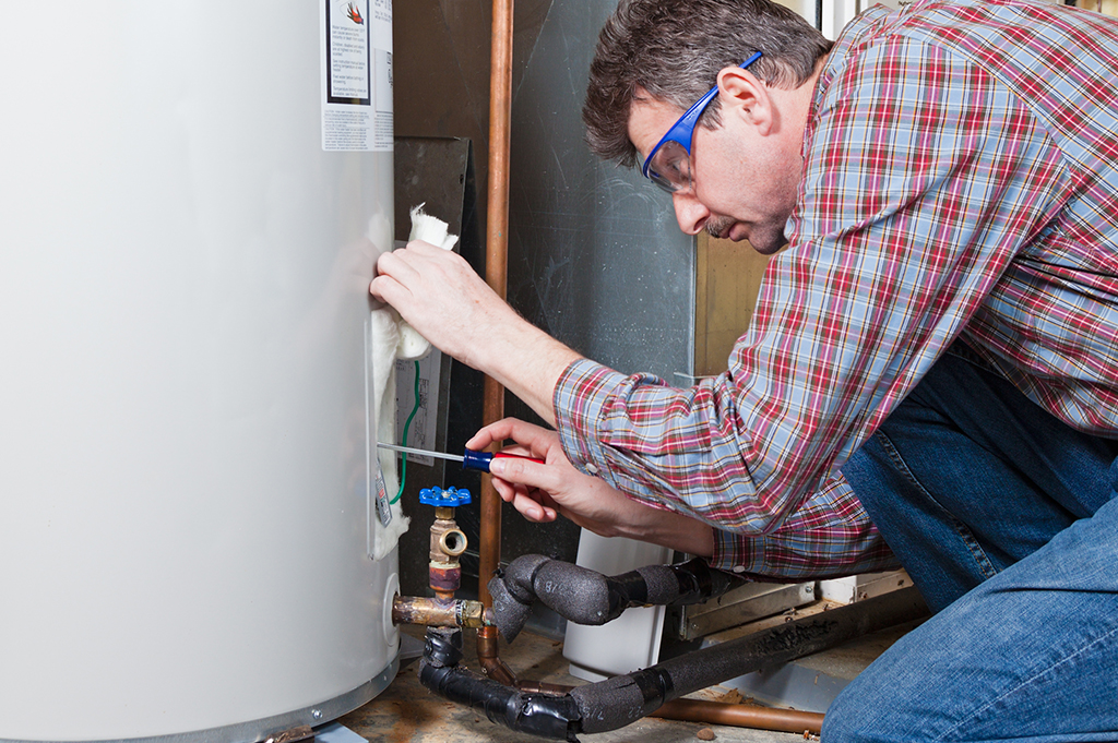Man servicing hot water heater